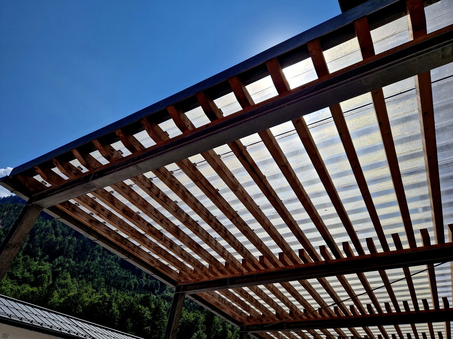 modern market stand made of metal pergola structure with slats on the sides of the walls. the striped appearance of the smoking shelters at the bus stop, beams overlap, tension wires, acrylic plastic