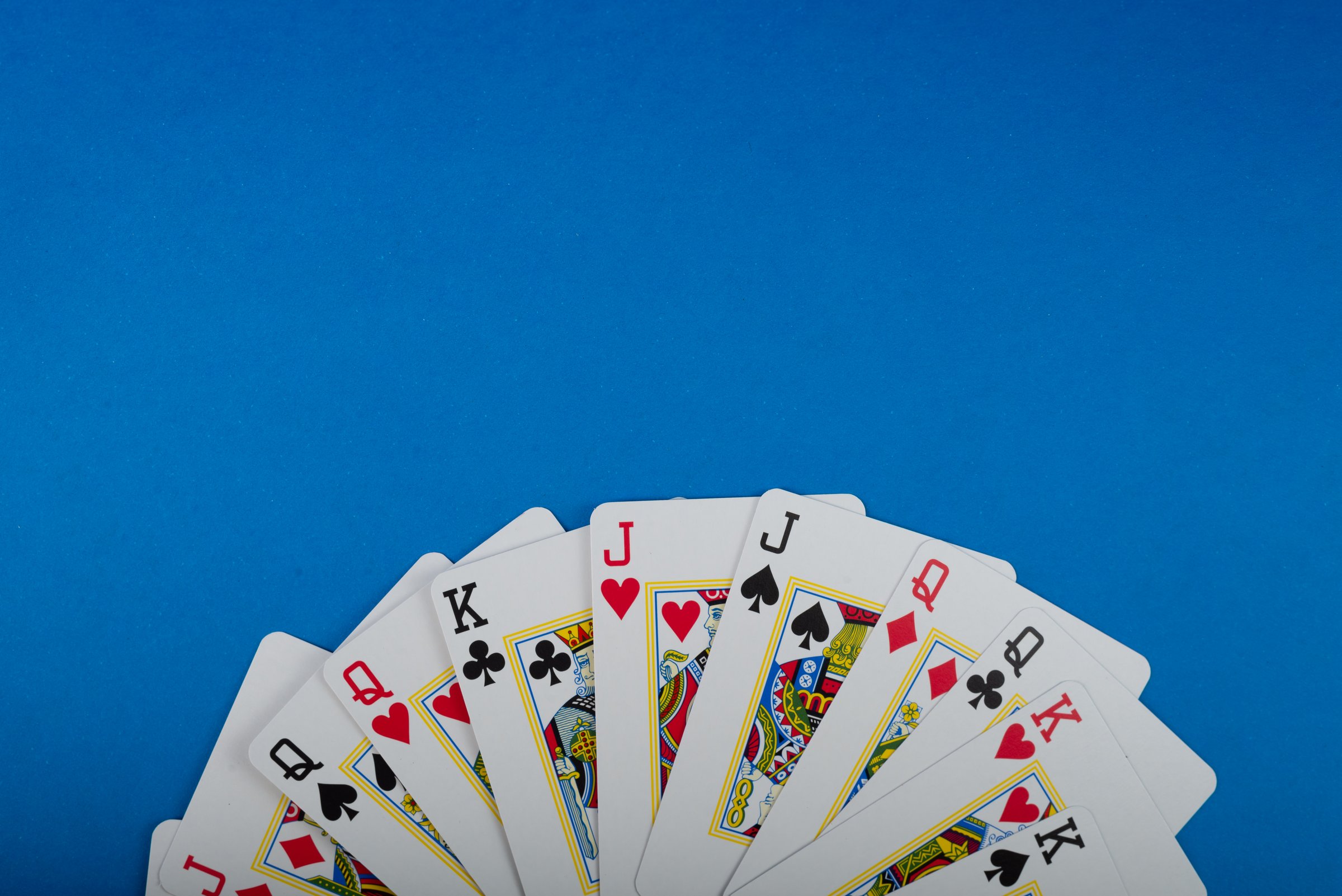 Playing cards isolated on blue background. Gambling.