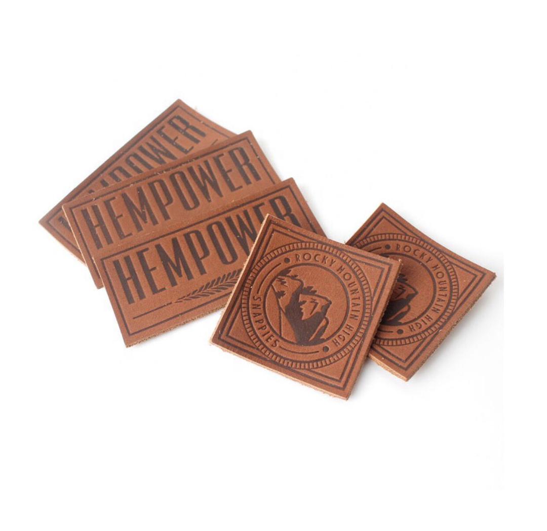 Leather patches with HEMPOWER and Rocky Mountain Desires logos displayed on a white background.