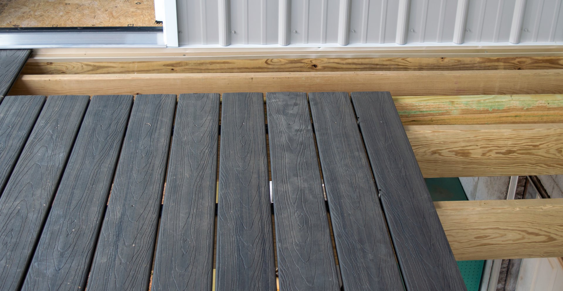 Grey colored composite decking is being installed on the new backyard deck. It will be a great home improvement.