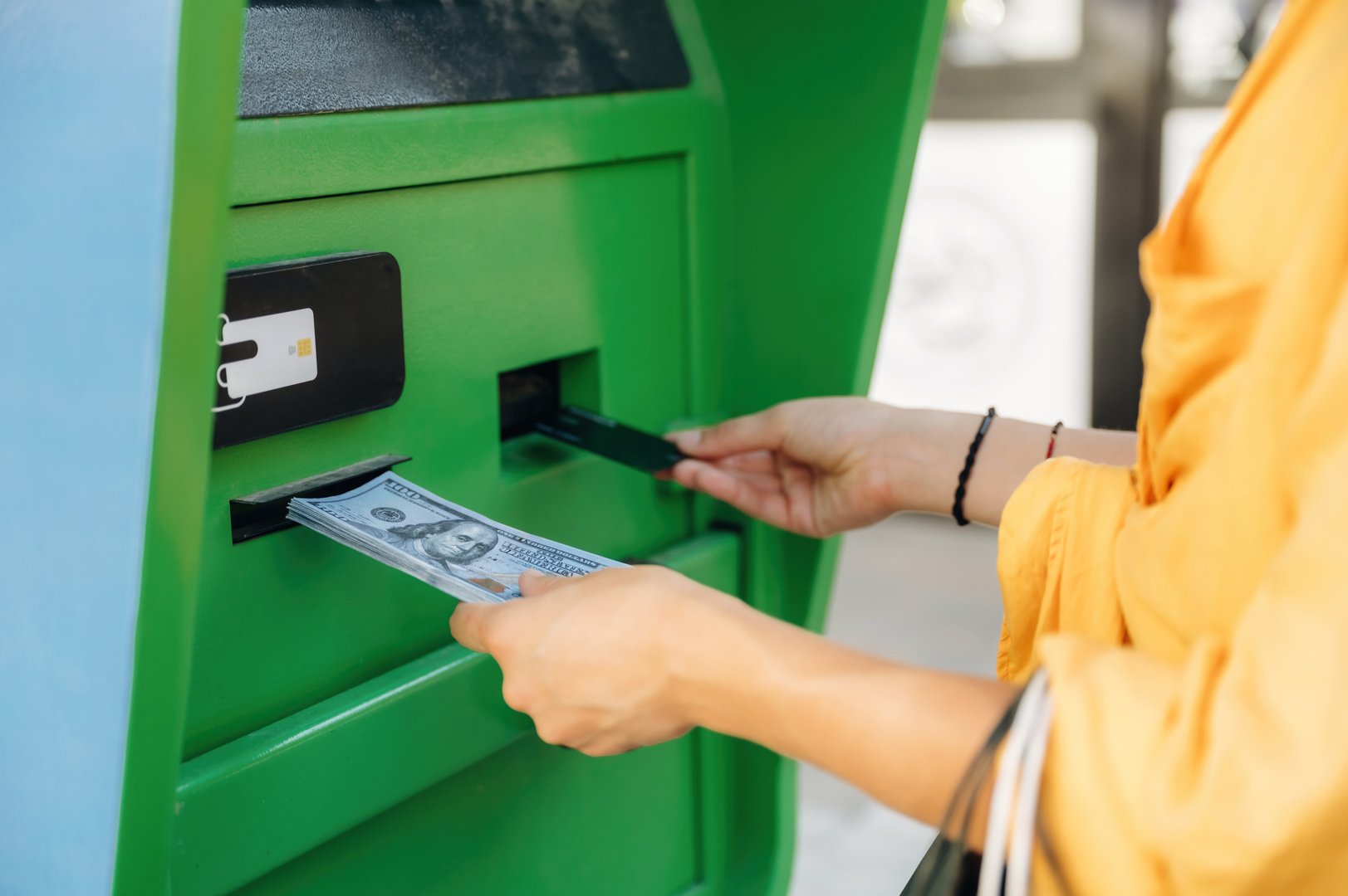 Close up view of woman with lot of cash using ATM