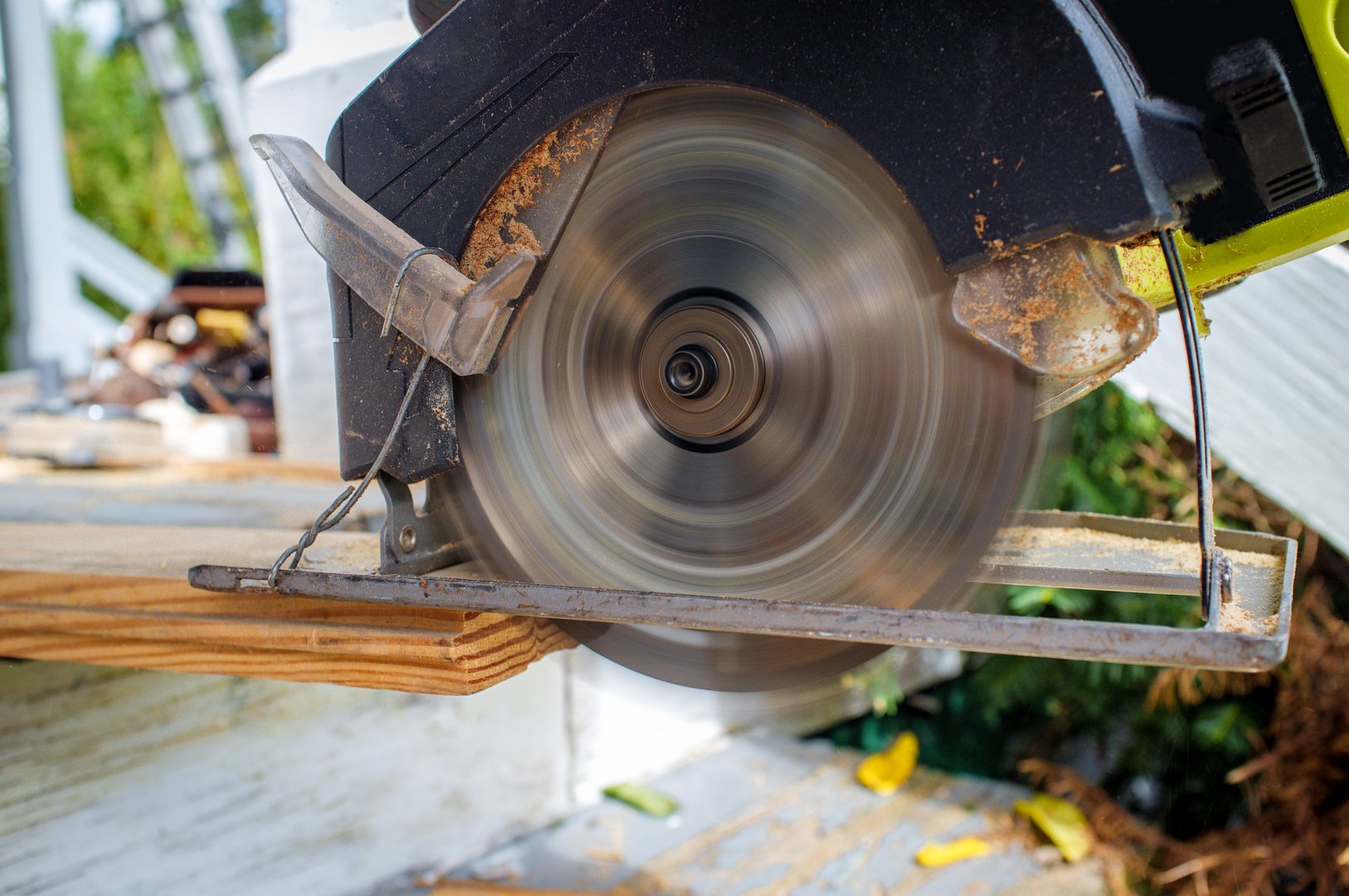 Old worn circular saw power tool cutting wood