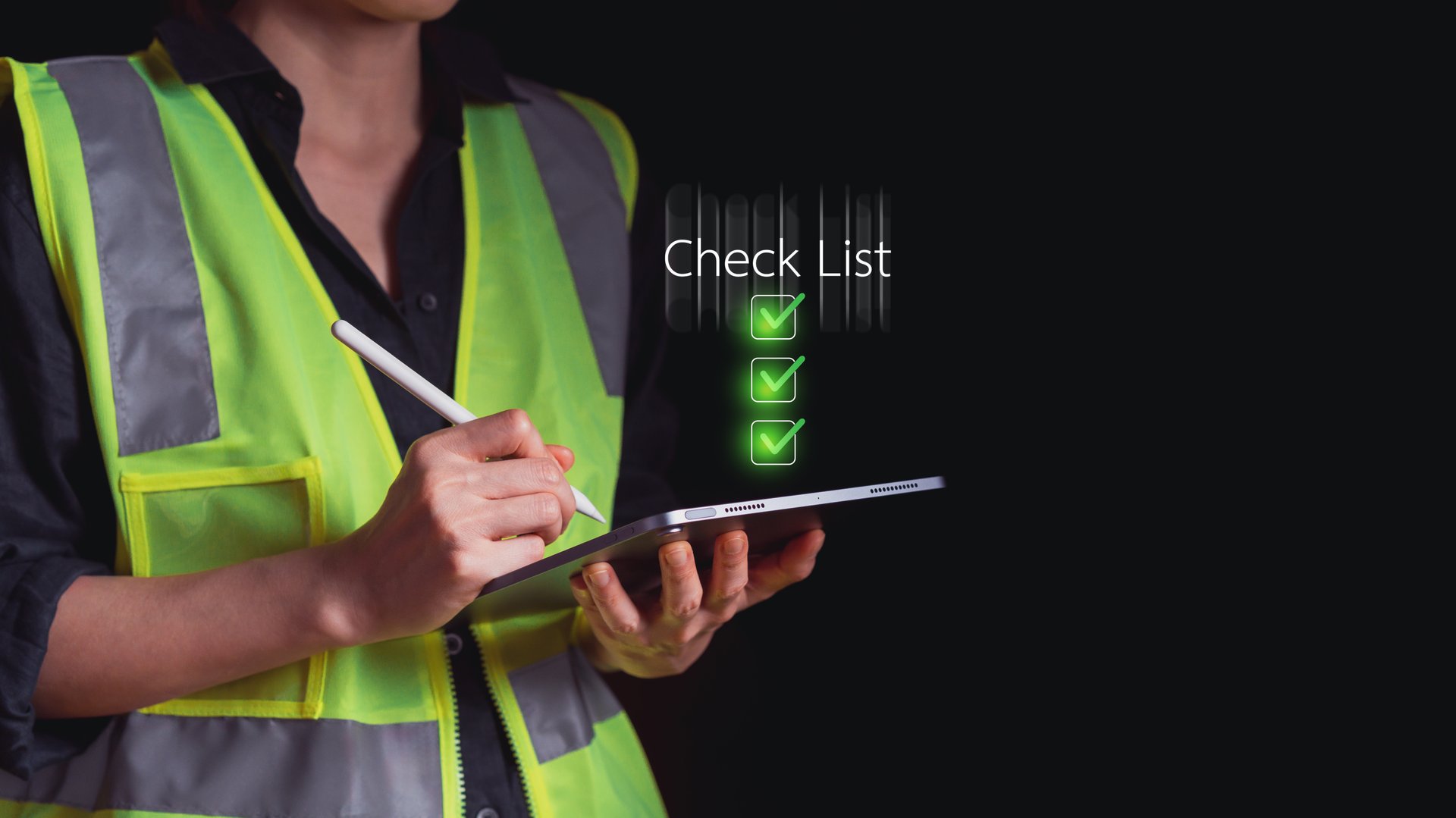 Engineer in high visibility safety vest using digital tablet for checklist with glowing green checkmarks. Concept of modern inspection, workplace safety, construction audit, and project control.