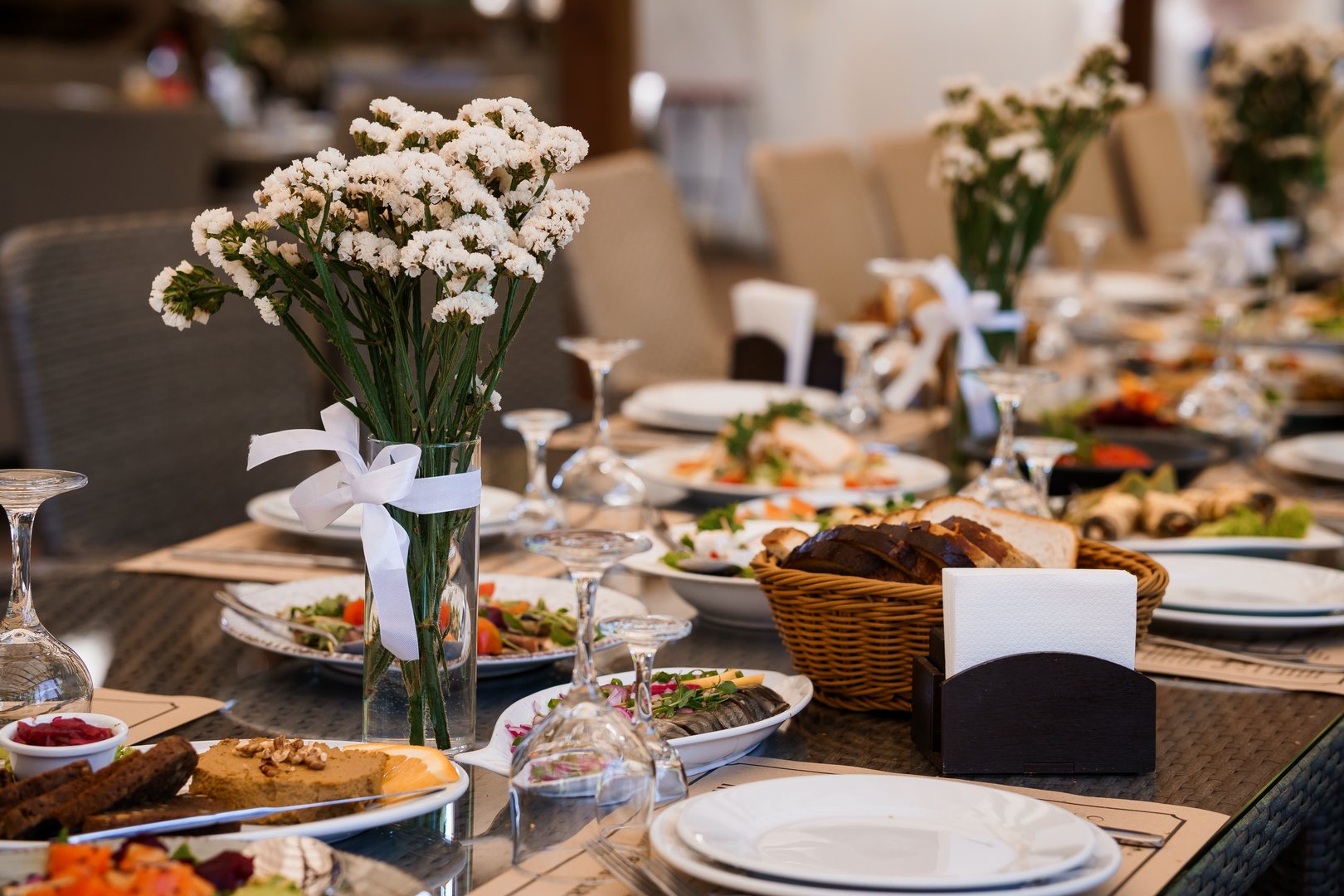 Elegant Dining Table Setting with Floral Arrangement and Gourmet Delicacies.