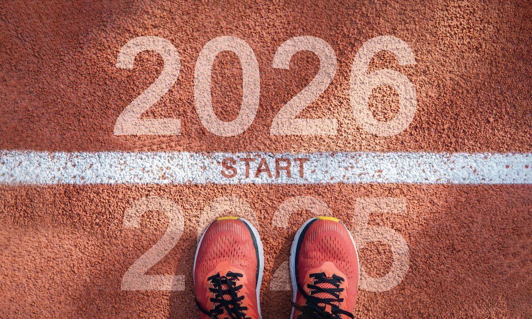 New year 2026 concept, beginning of success. Text 2026 written on asphalt road and male runner preparing for the new year. Concept of challenge or career path and change.