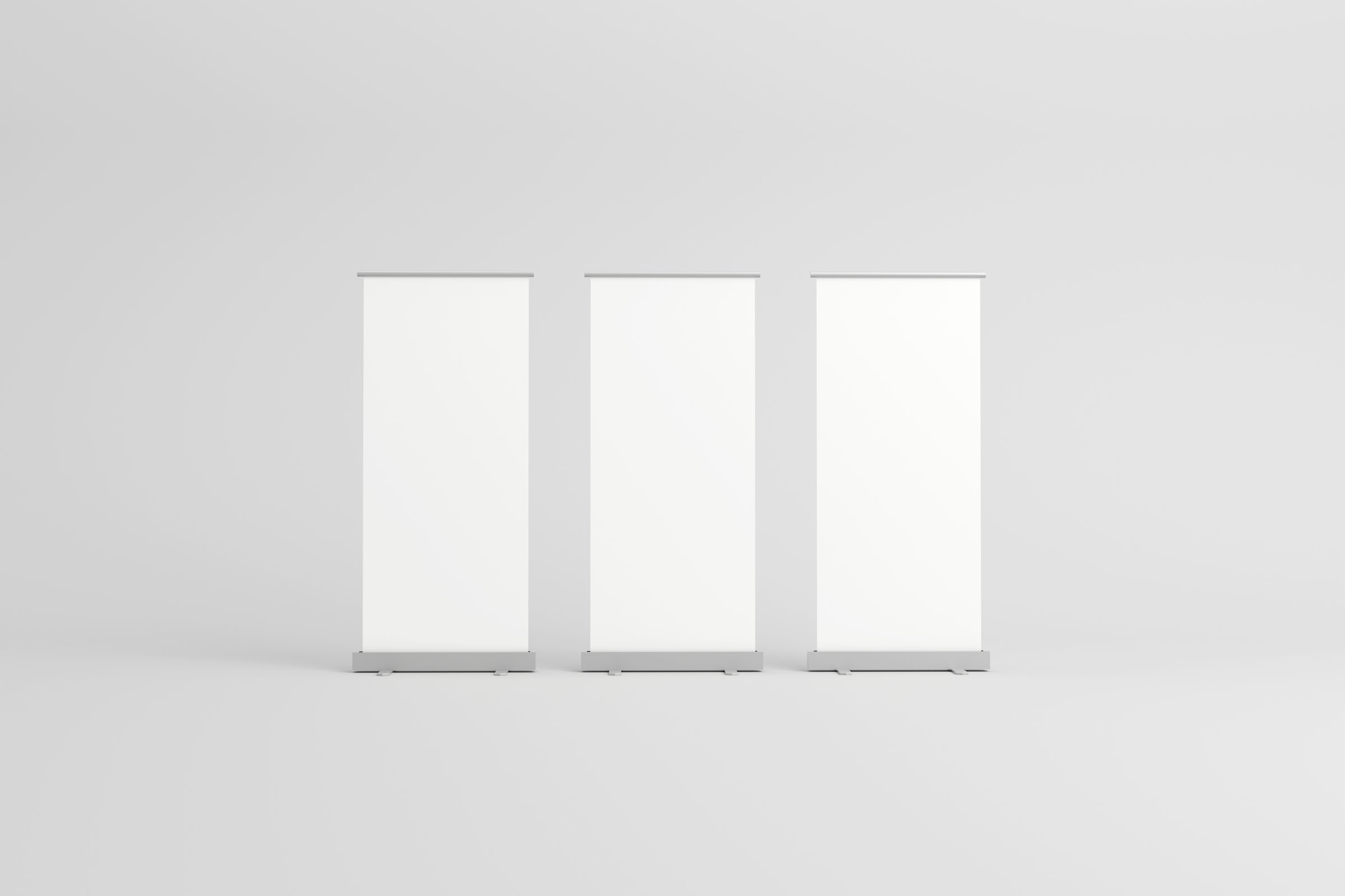 Three empty roll-up banners with white backgrounds, lined up side by side, ideal for customizable branding in exhibitions, trade shows, or promotional events.