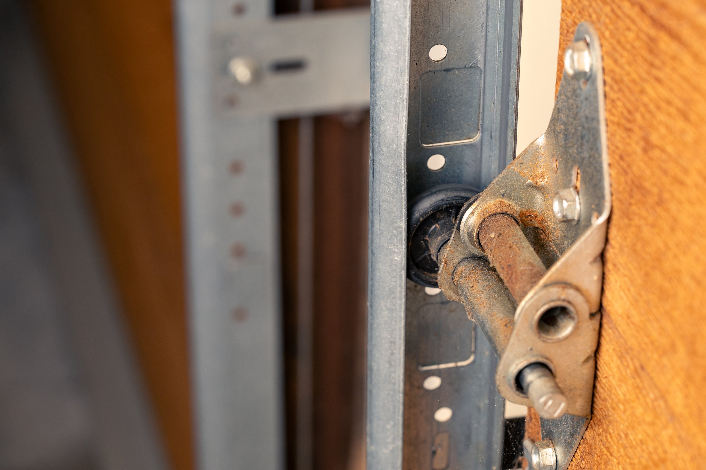 Close up of garage door hinge and roller on wooden door, selective focus.