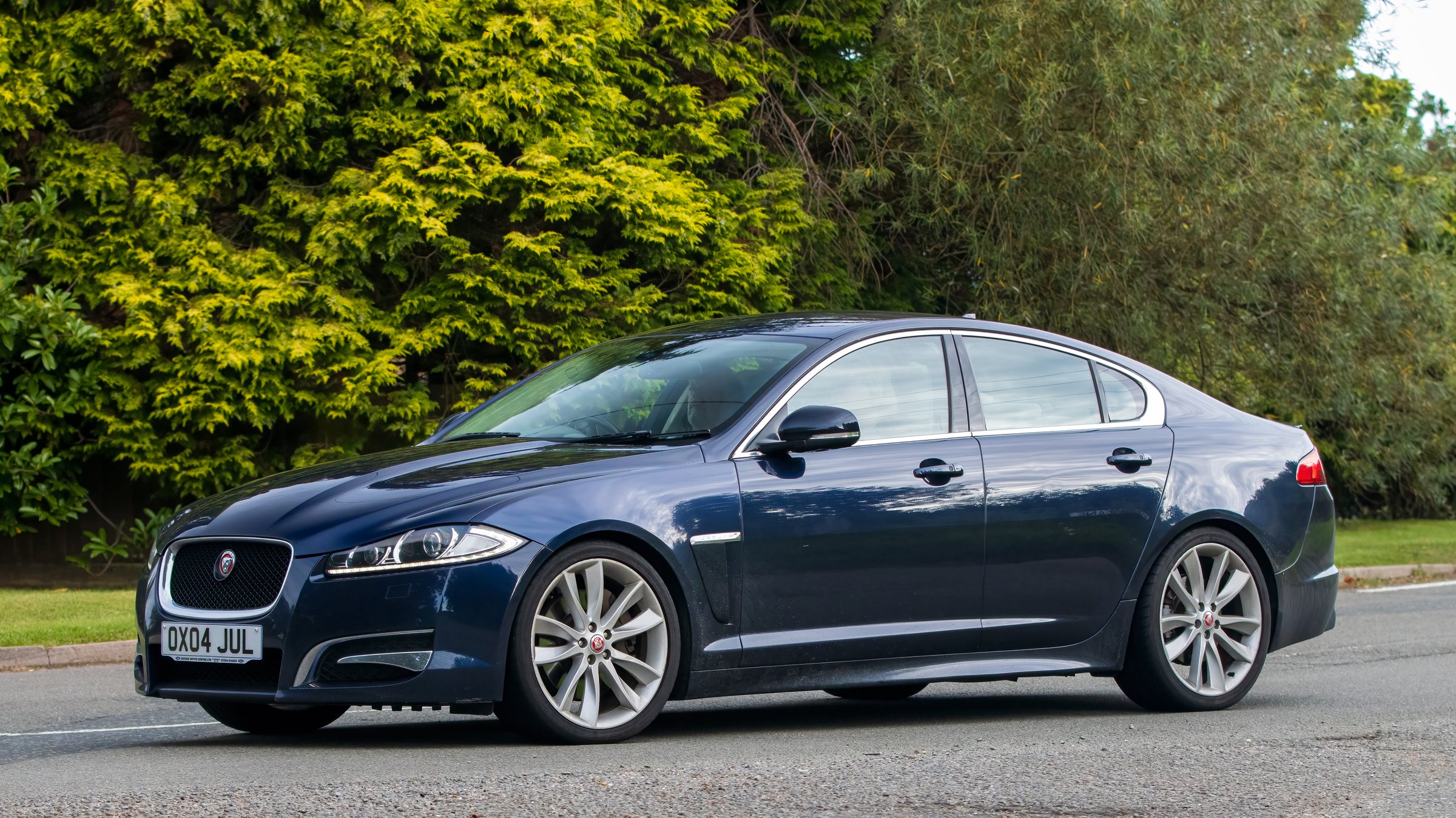 Whittlebury,Northants,UK -Aug 27th 2023:  2013 blue Jaguar XF car travelling on an English country road