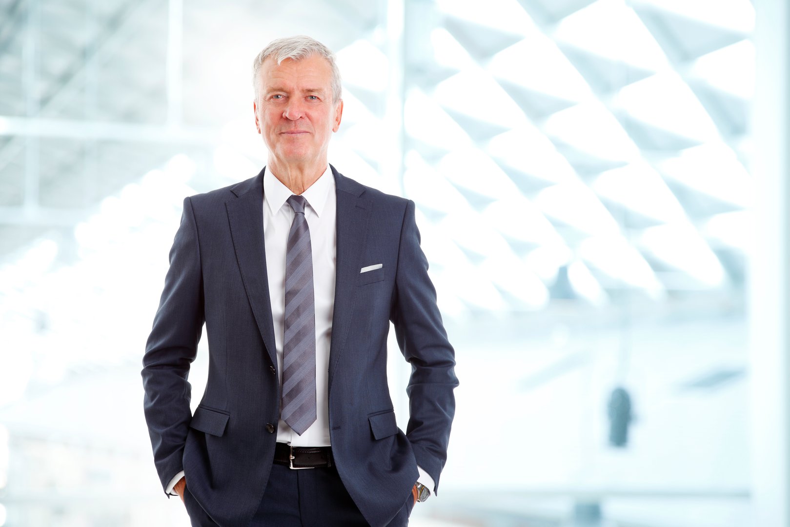Portrait of executive financial director standing at office while looking at camera and smiling.
