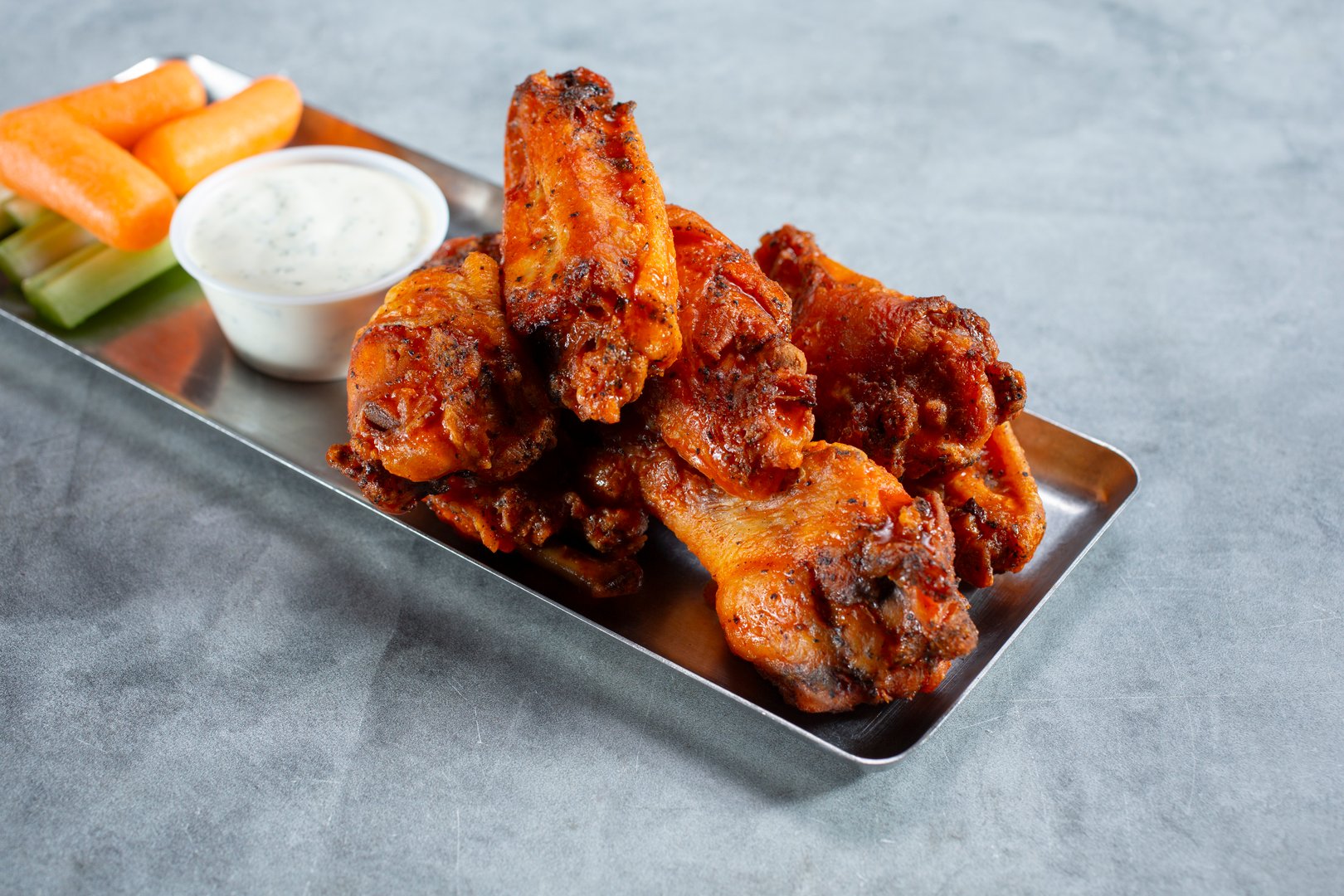 A view of a metal tray of Buffalo wings