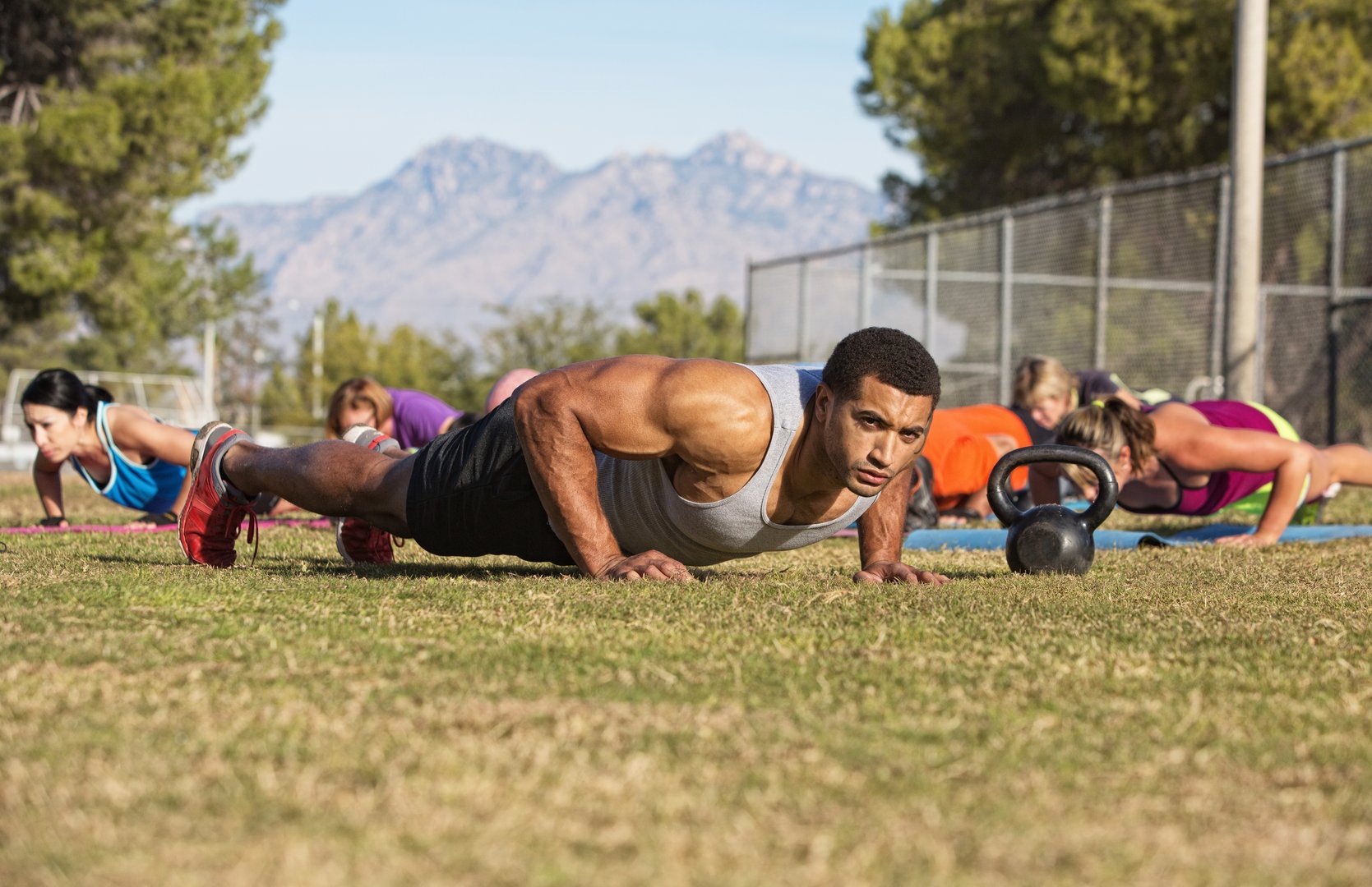 Outdoor exercise boot camp fitness group near mountain