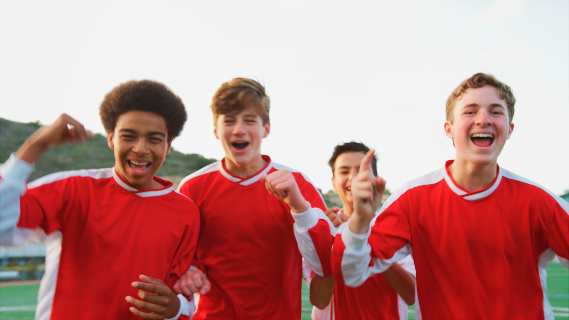 Portrait Of Multi-Cultural Male High School Soccer Team Celebrating Looking Into Camera
