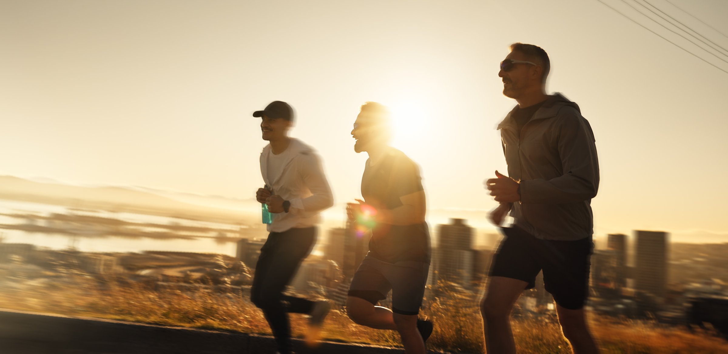 Men, fitness and running with sunset for workout, exercise or outdoor training together on mountain. Active, male people or runners with sunshine for sprint, race or health and wellness in nature