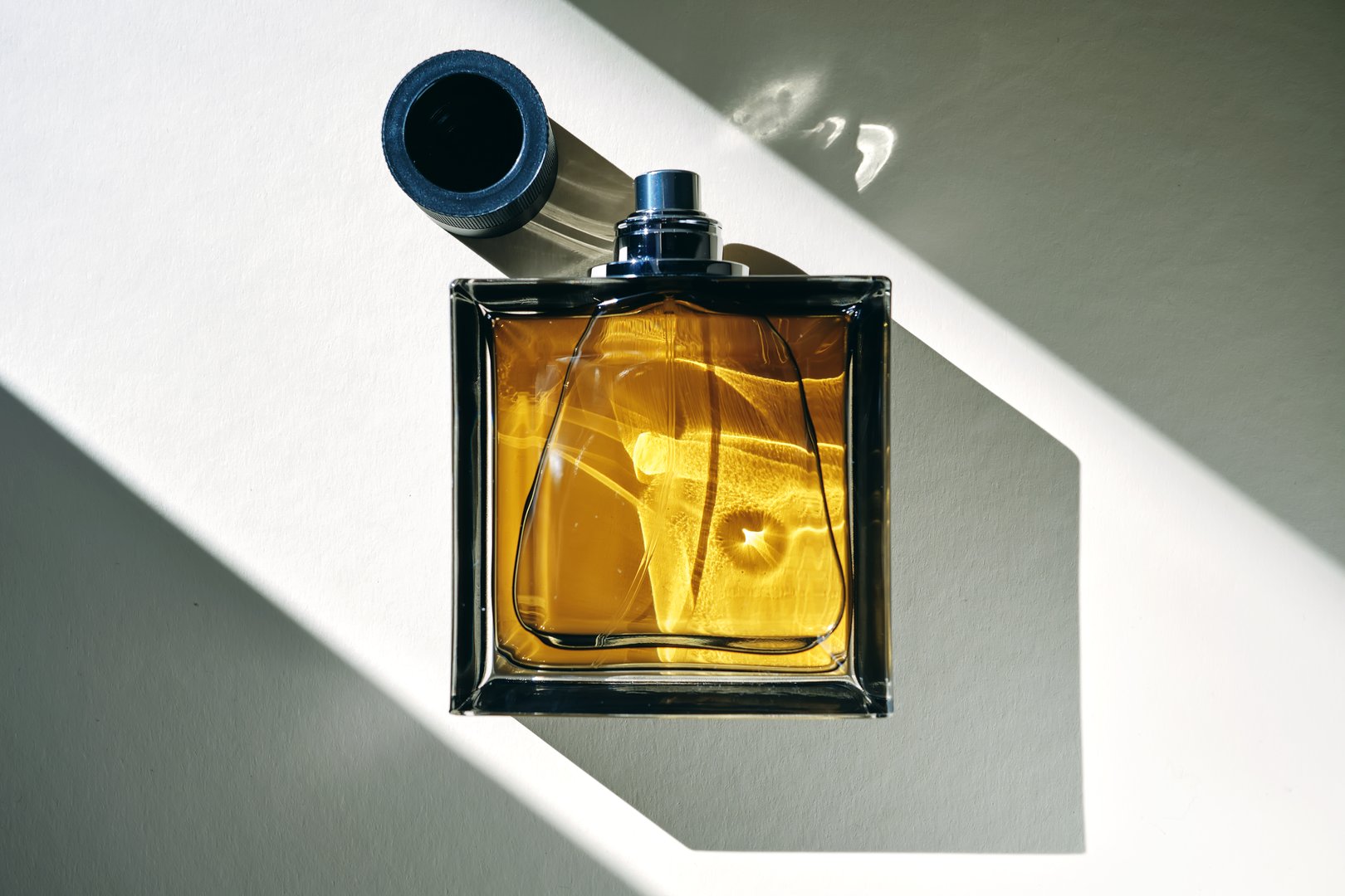 A golden bottle of perfume in a sunbeam. High quality photo.