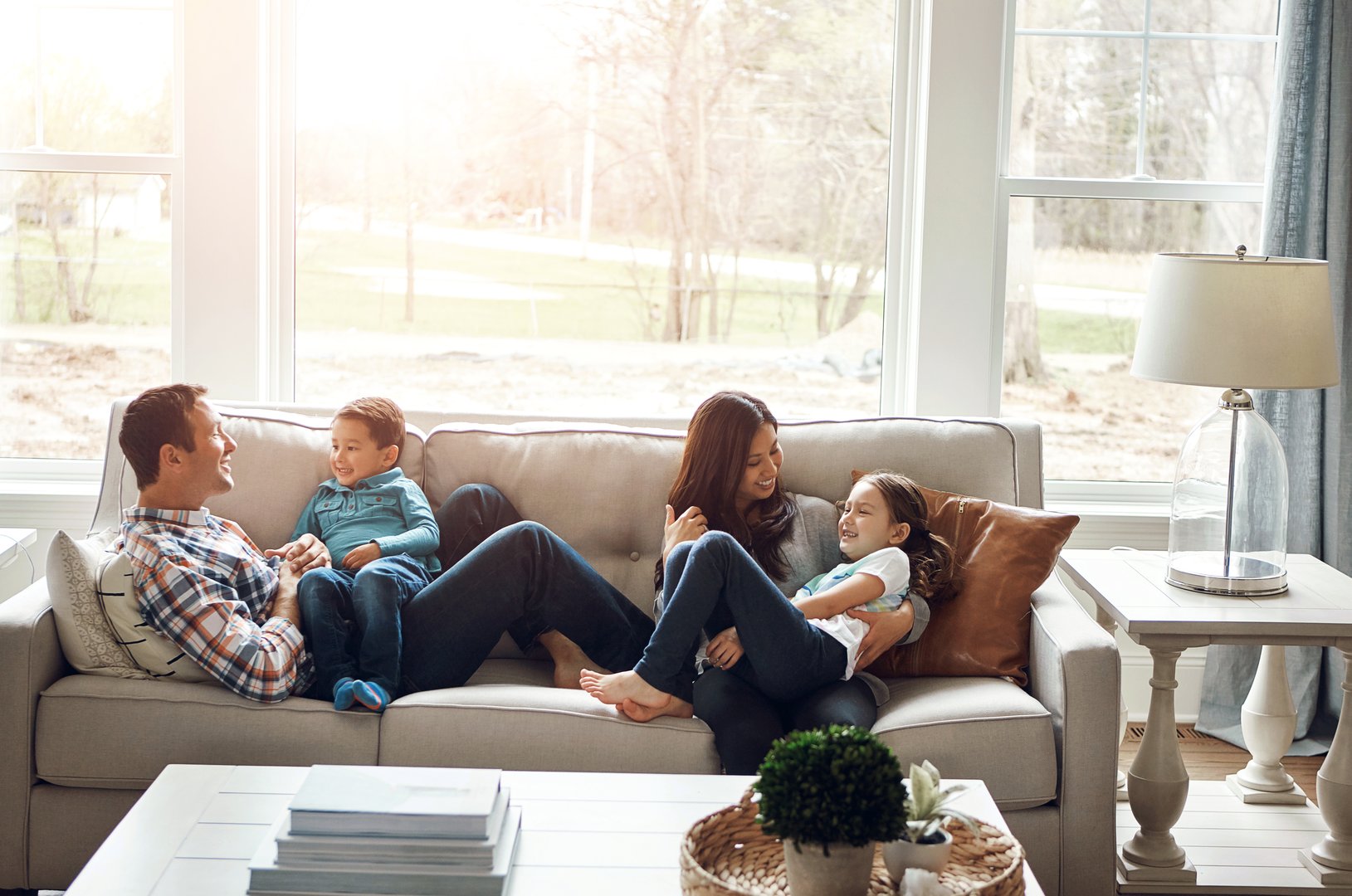 Happy family relaxing in a clean, bright bedroom with natural light in a Southern California home after pest treatment