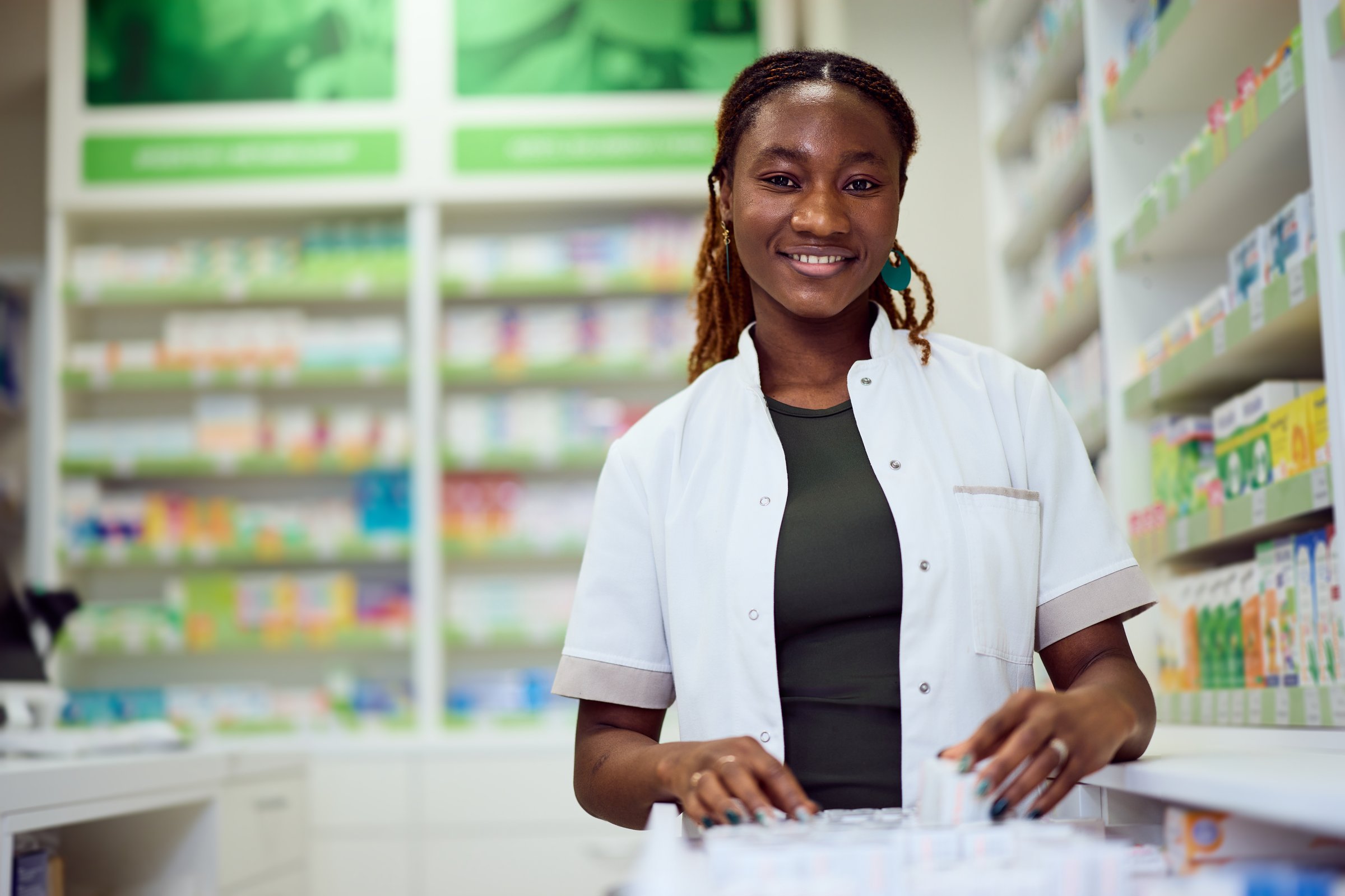 Confident female pharmacist standing in a pharmacy, showcasing dedication to healthcare.