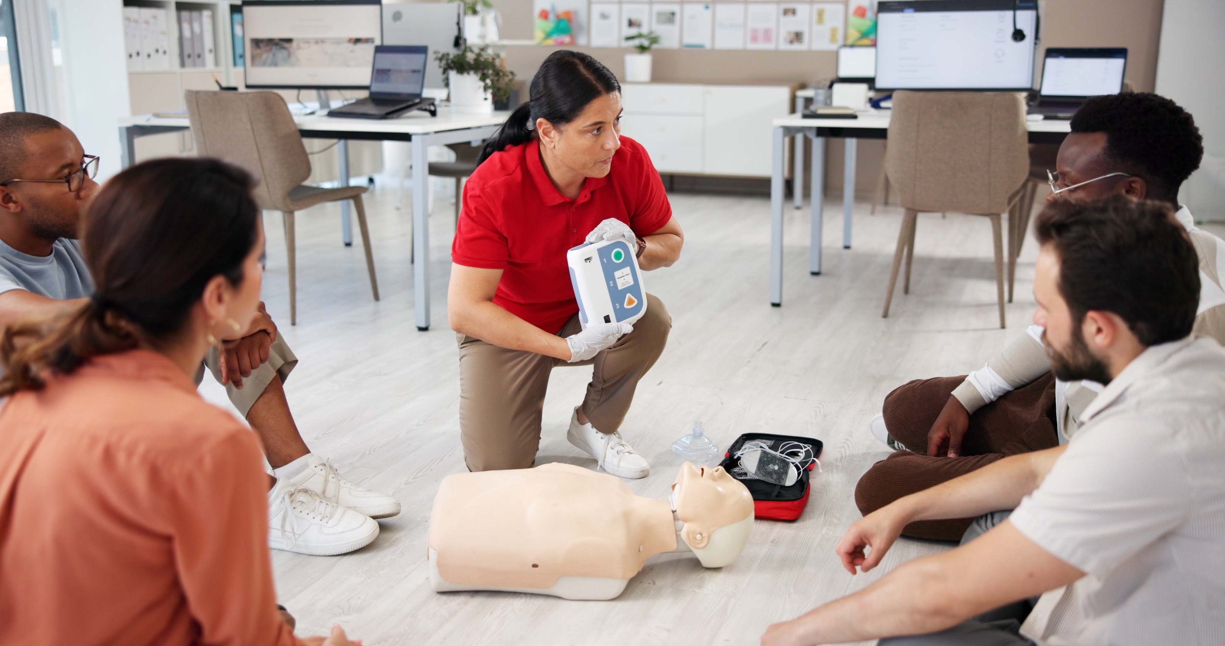Mannequin, cpr and training with people and defibrillator for first aid workshop, cardiac arrest rescue or safety protocol. Healthcare class, medical simulation and heart rhythm with paramedic course