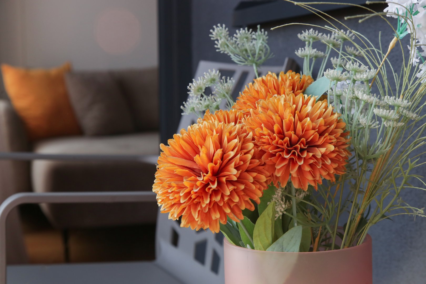 Nice orange flowers in vase on the balcony table, home decor concept