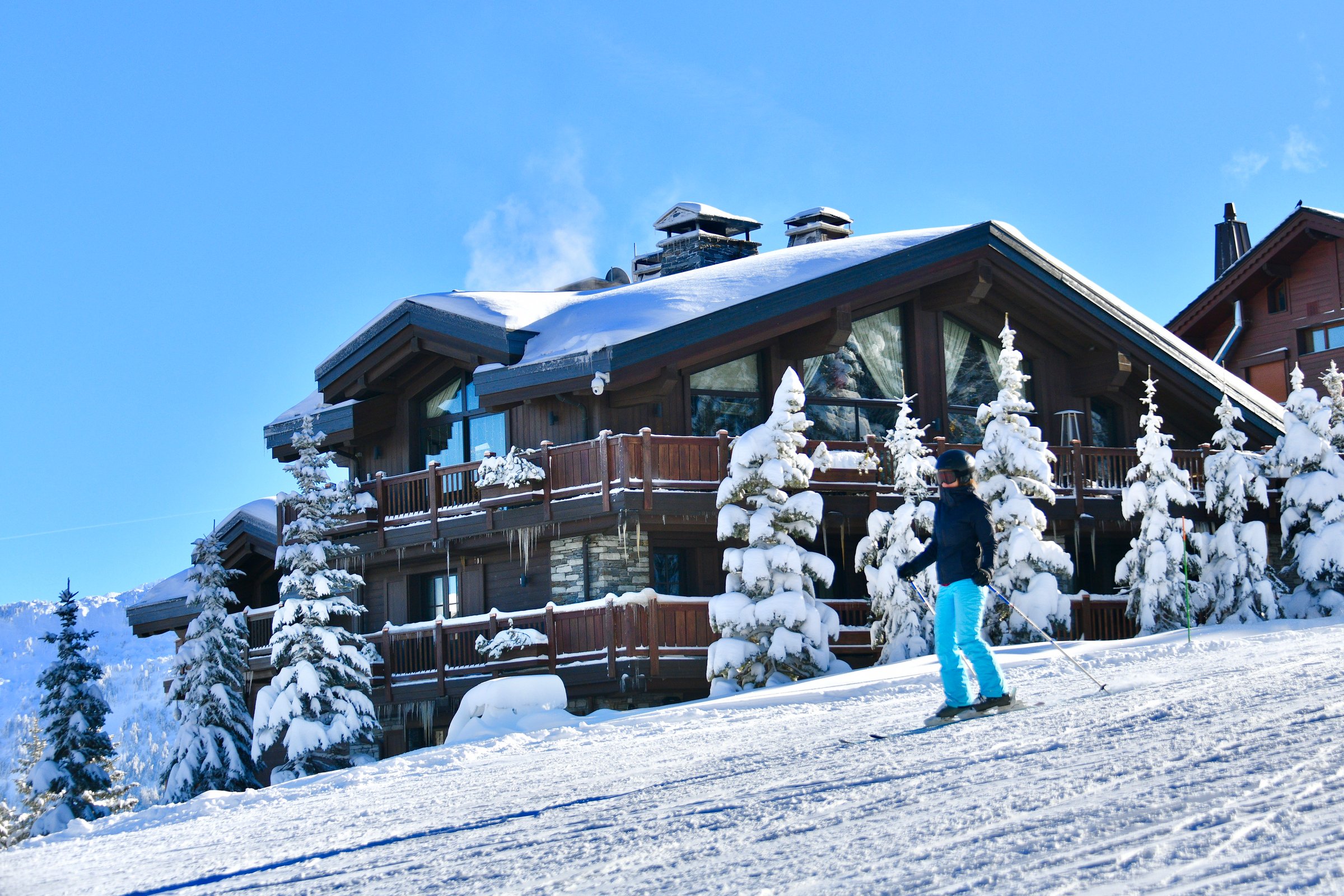 Skiing people on the slopes of Courchevel ski resort, in front of the luxury chalets by winter, Courchevel, Rhône alps, French alps on 12/24/2024