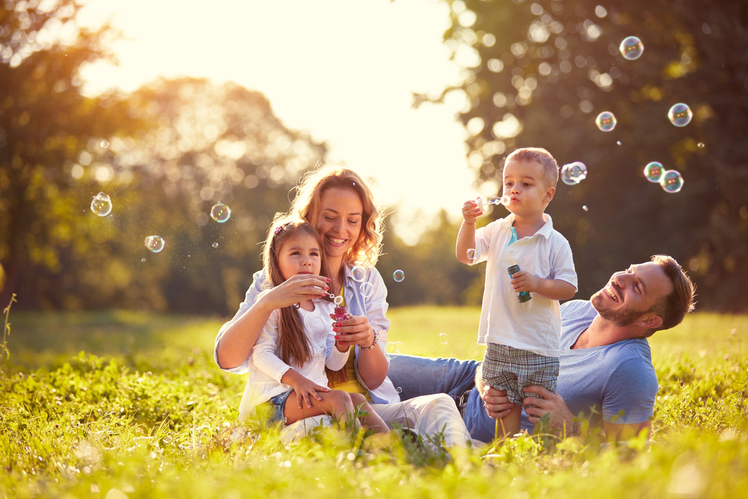 Family with children blow soap bubbles nature