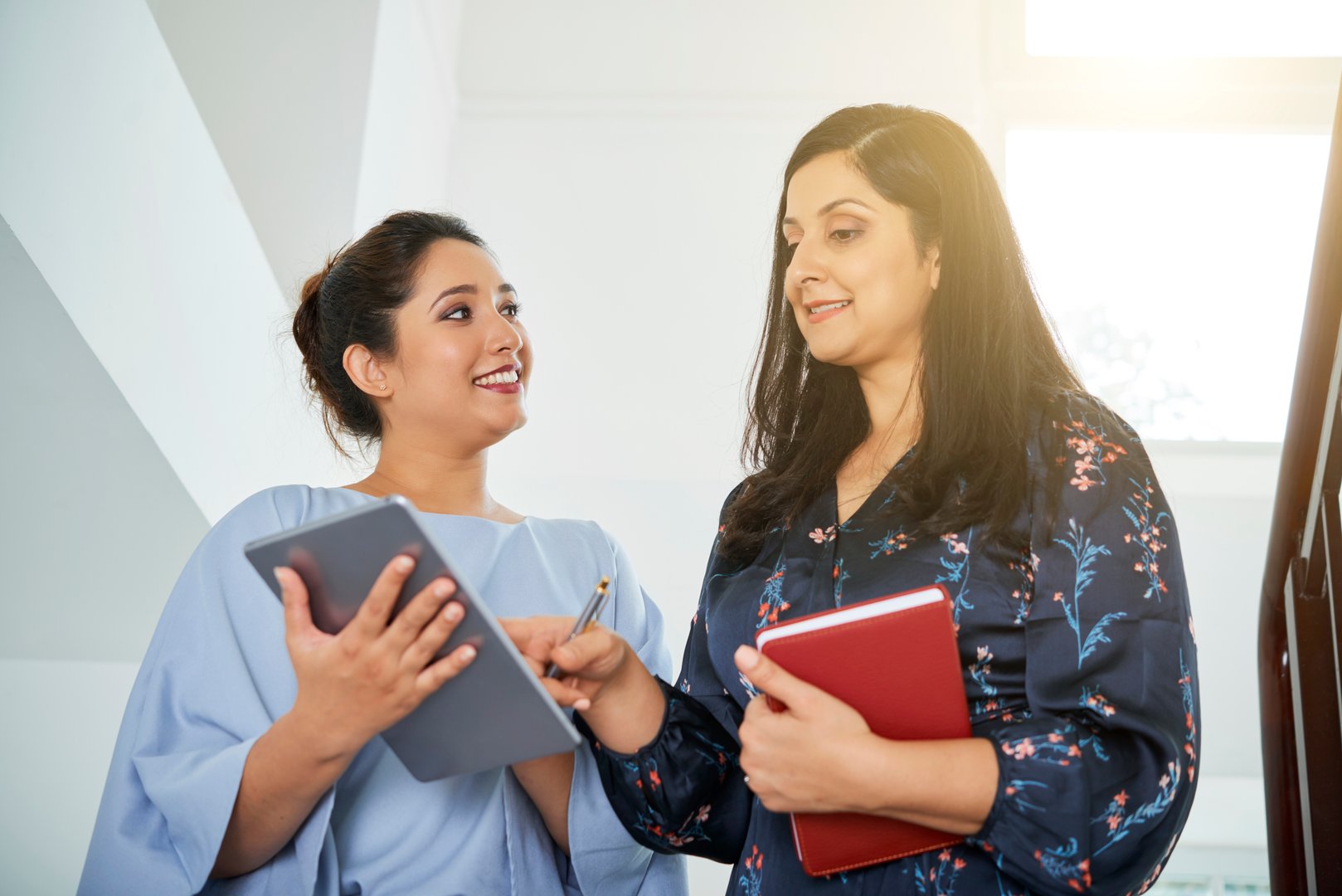 Confident Indian business lady checking report of her employee