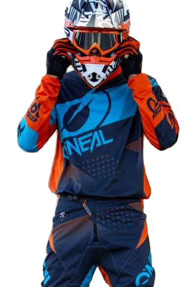 Person in colorful motocross gear adjusting helmet outdoors.