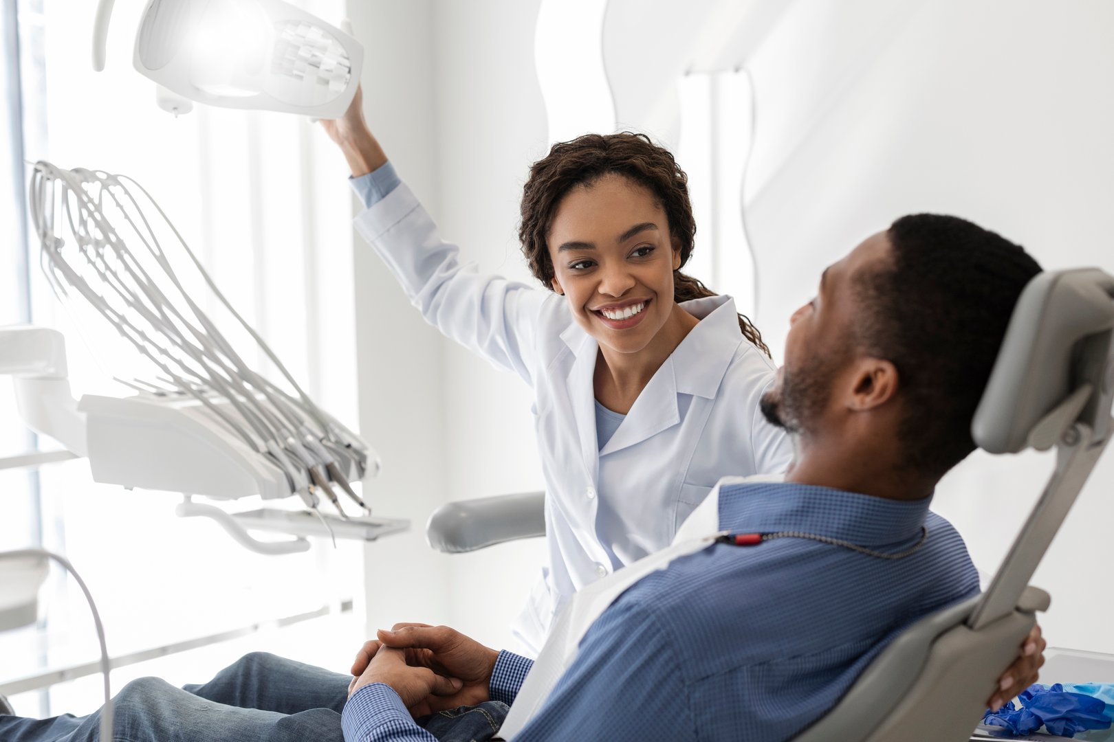 African woman dentist greeting patient in dental clinic