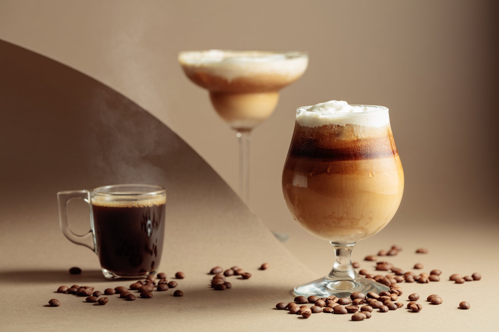 Black coffee and iced coffee cocktails on a beige background. Copy space.
