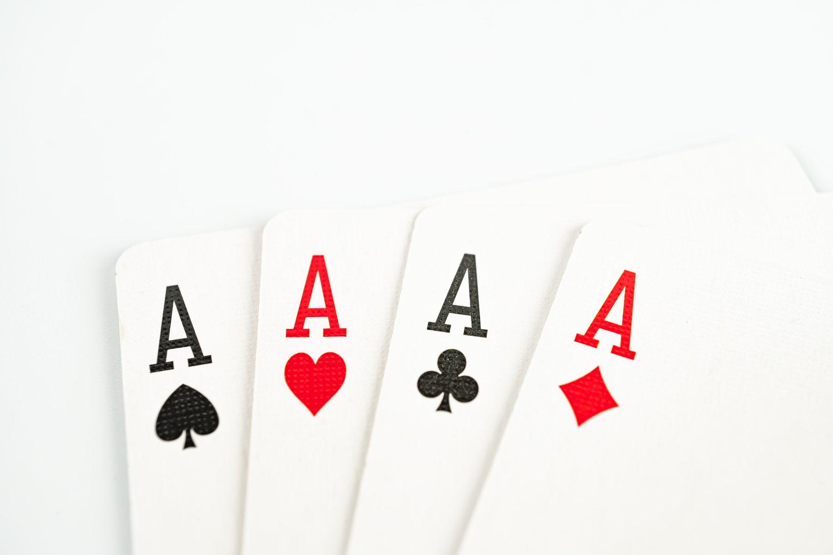 A close-up photo of five Ace cards, with hearts on top, in a line, emphasizing the central cards importance and symbolizing high value or winning strategies
