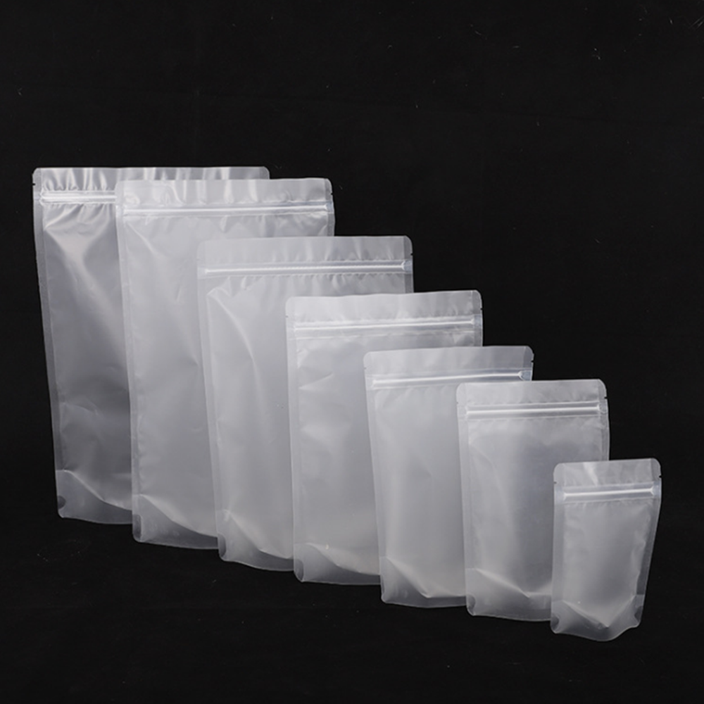 Seven white stand-up pouches of varying sizes against a black background.
