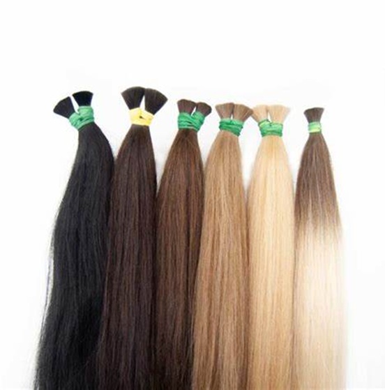 Six bundles of hair extensions in varying shades, from black to light blonde, tied with green bands.