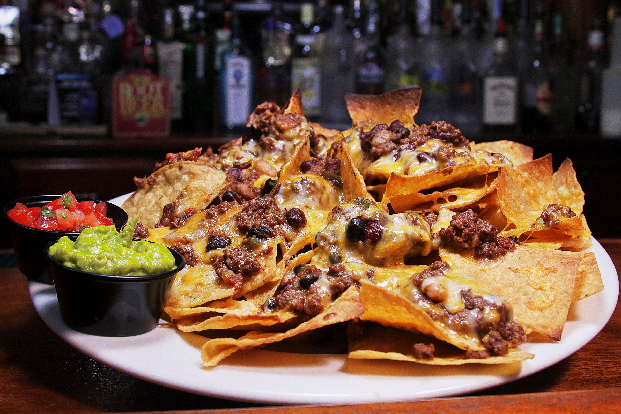 ground beef chili nachos with salsa and guacamole