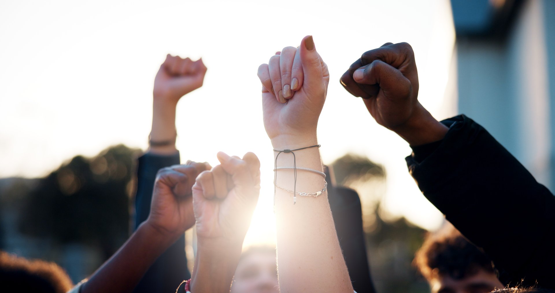 Hands, fist and students with protest outdoor for education riot, university equality and change law. Group, people and power with call to action for free learning, society support and racism justice