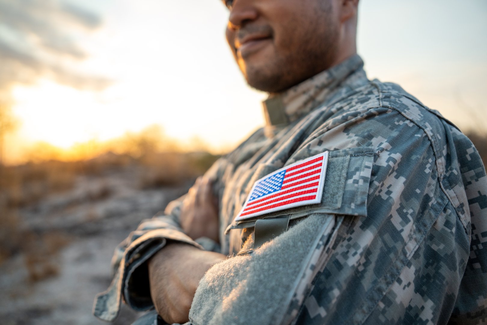 Hand Waving the Flag of the United States of America in memorial day . Us soldier holding American flag celebrating.US Army soldier celebrates holding USA flag celebrating Independence USA day