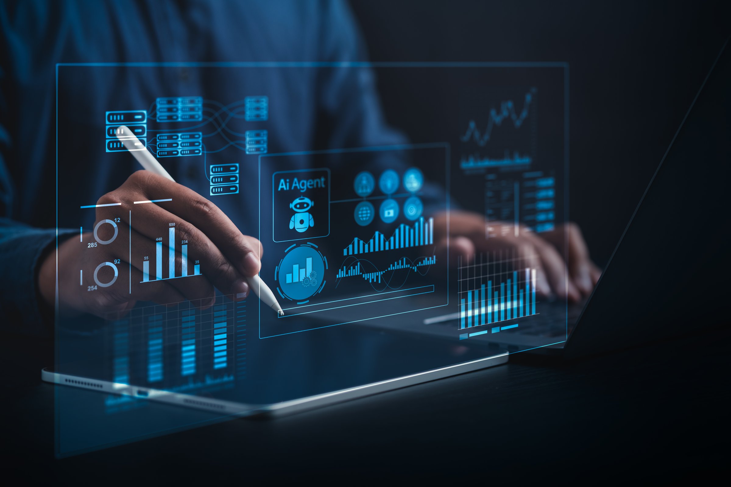 AI Business Analyst Collaborating with Virtual AI Agent to Analyze Big Data in Real Time on a Holographic Dashboard with Computers and Laptops in a Dark Blue-Lit Room