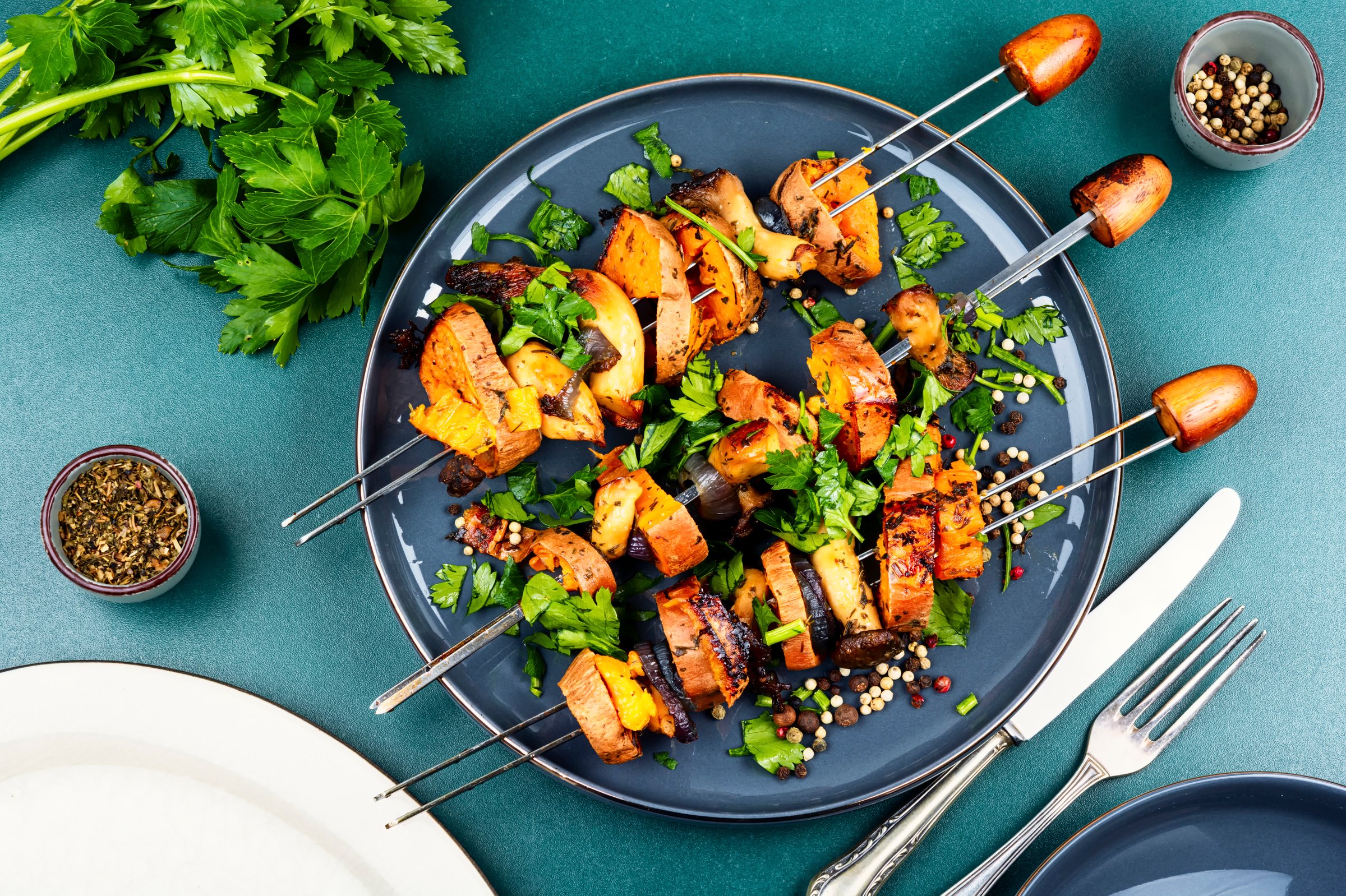 Sweet potato, aromatic herbs and mushrooms baked on skewers. Grilled vegetable shashlik. Healthy and vibrant summer dish. Flat lay