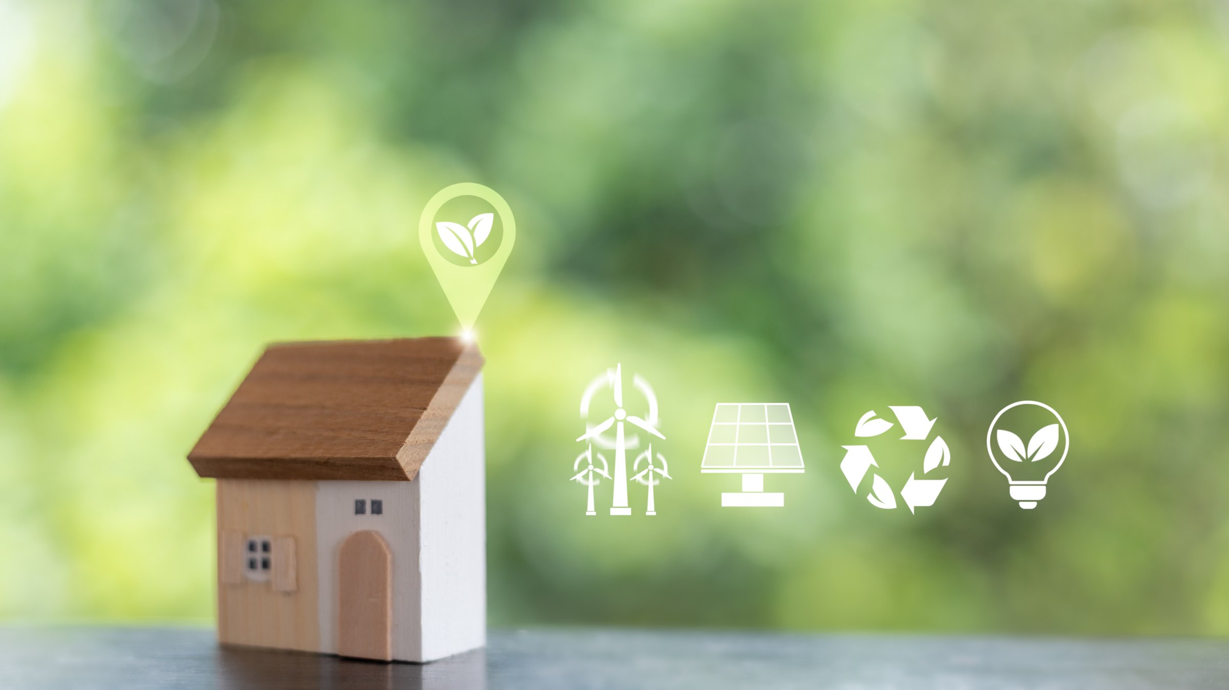 Wooden eco house model with icons of renewable energy, solar panel, wind turbine, recycling, and green technology. Concept of sustainable living, eco-friendly housing, and environmental conservation.
