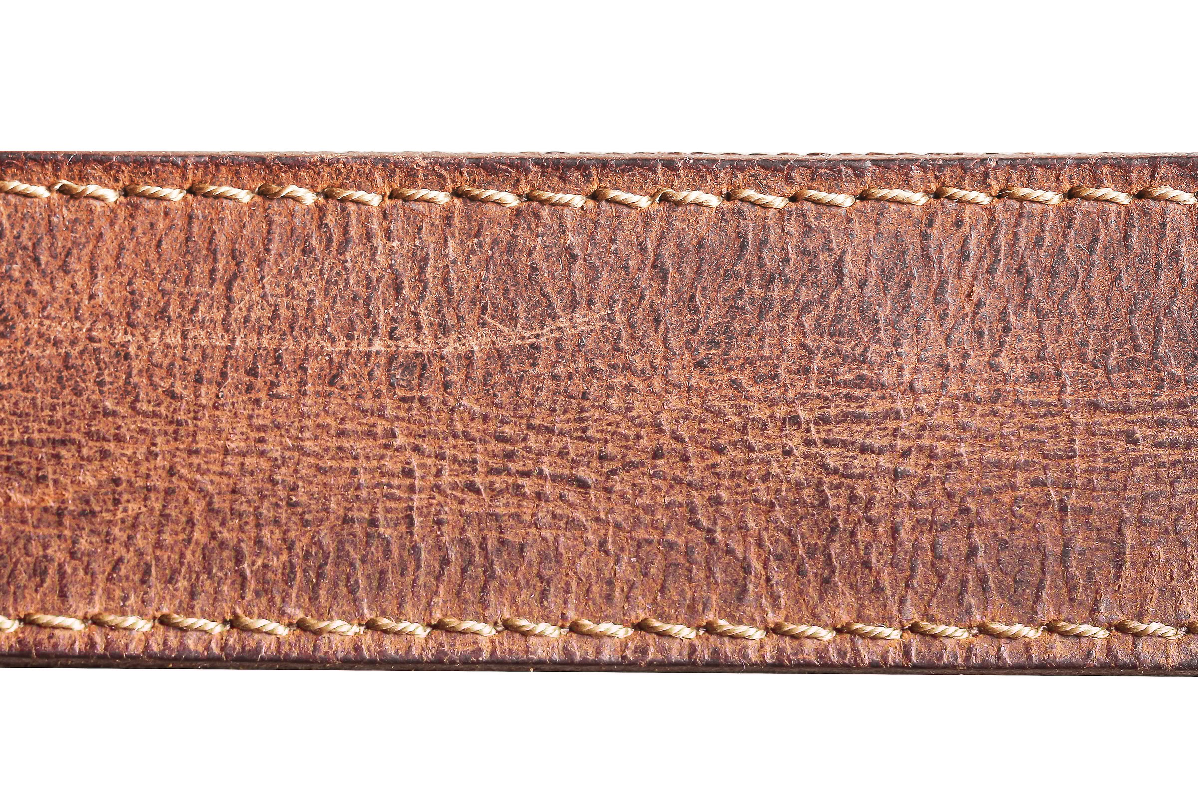 Handcrafted accessory detail. Vintage fashion style concept. Natural leather surface.