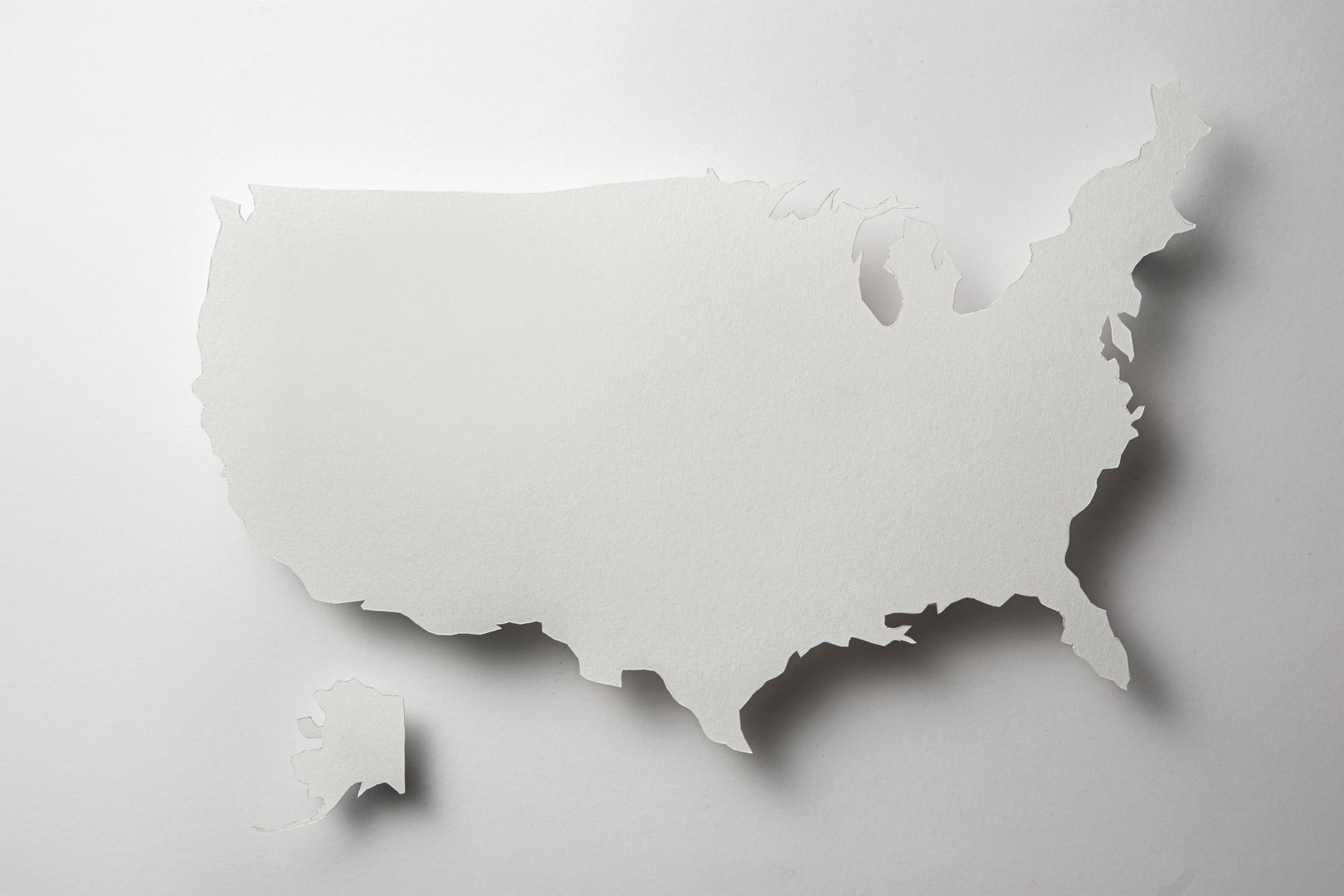 USA map paper texture cut out with shadow on white background.