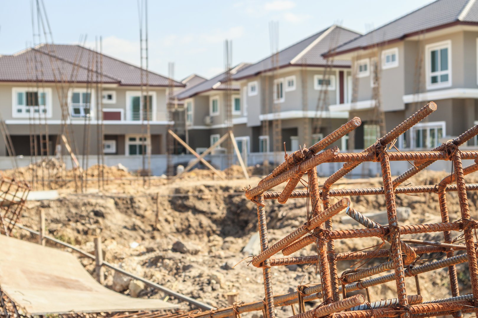 New residential house contemporary style building in progress at construction site with blue sky