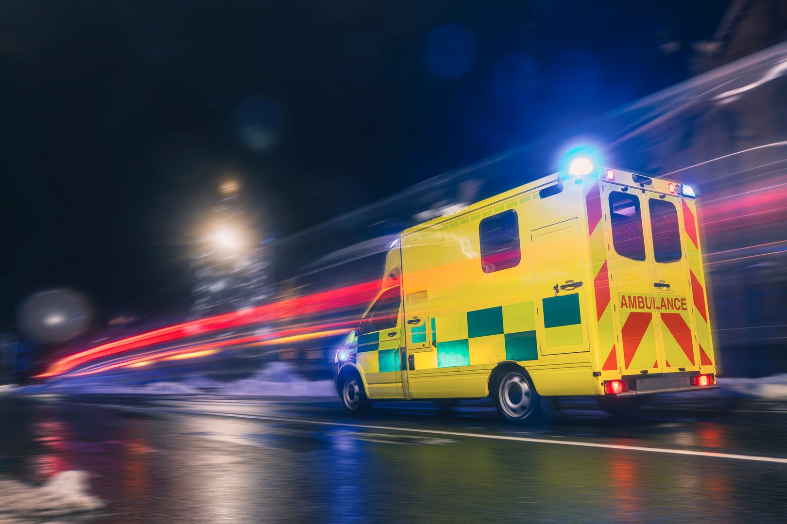 Ambulance car of emergency medical service in blurred motion on road at night. Themes health care, rescue, accidents and disasters.