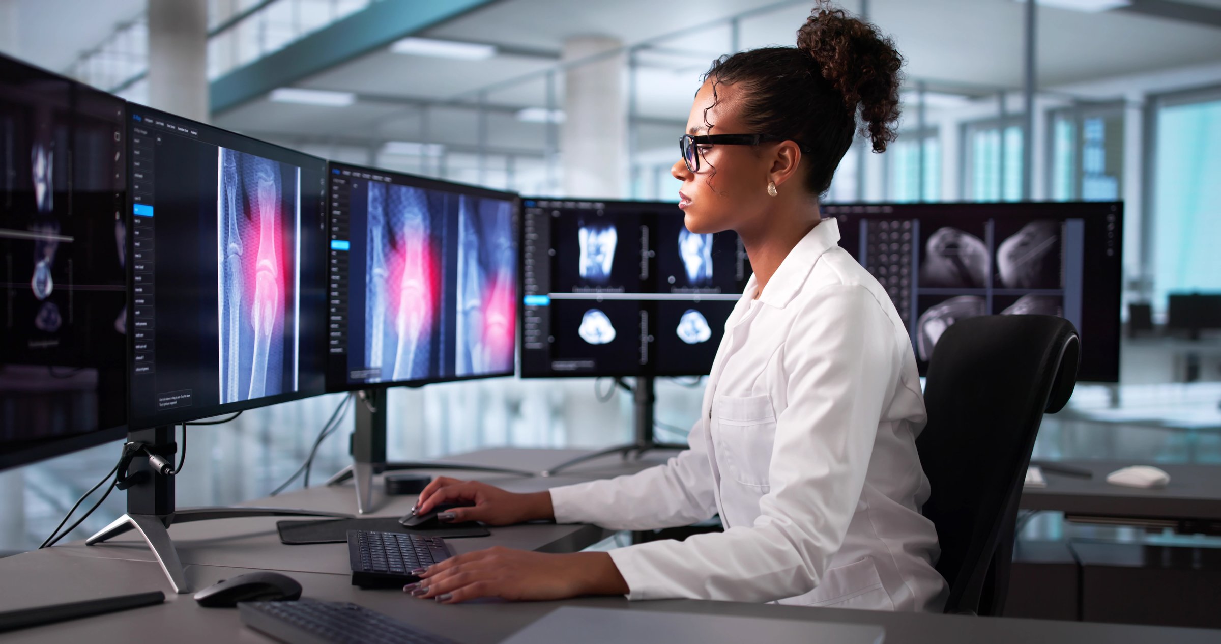 Female African-American Doctor Performs Knee Bone Surgery Using X-ray Software.