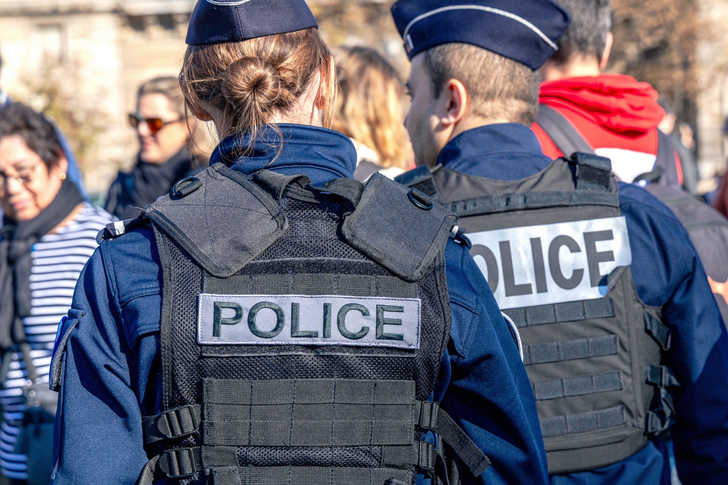 Two policemen, a man and a woman, wearing bulletproof vest with the word police on them. Paris, France - November 1, 2024