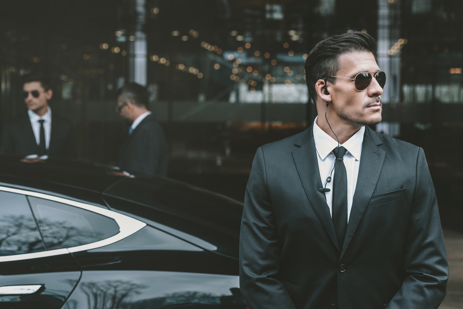 Bodyguard standing at businessman car protecting client