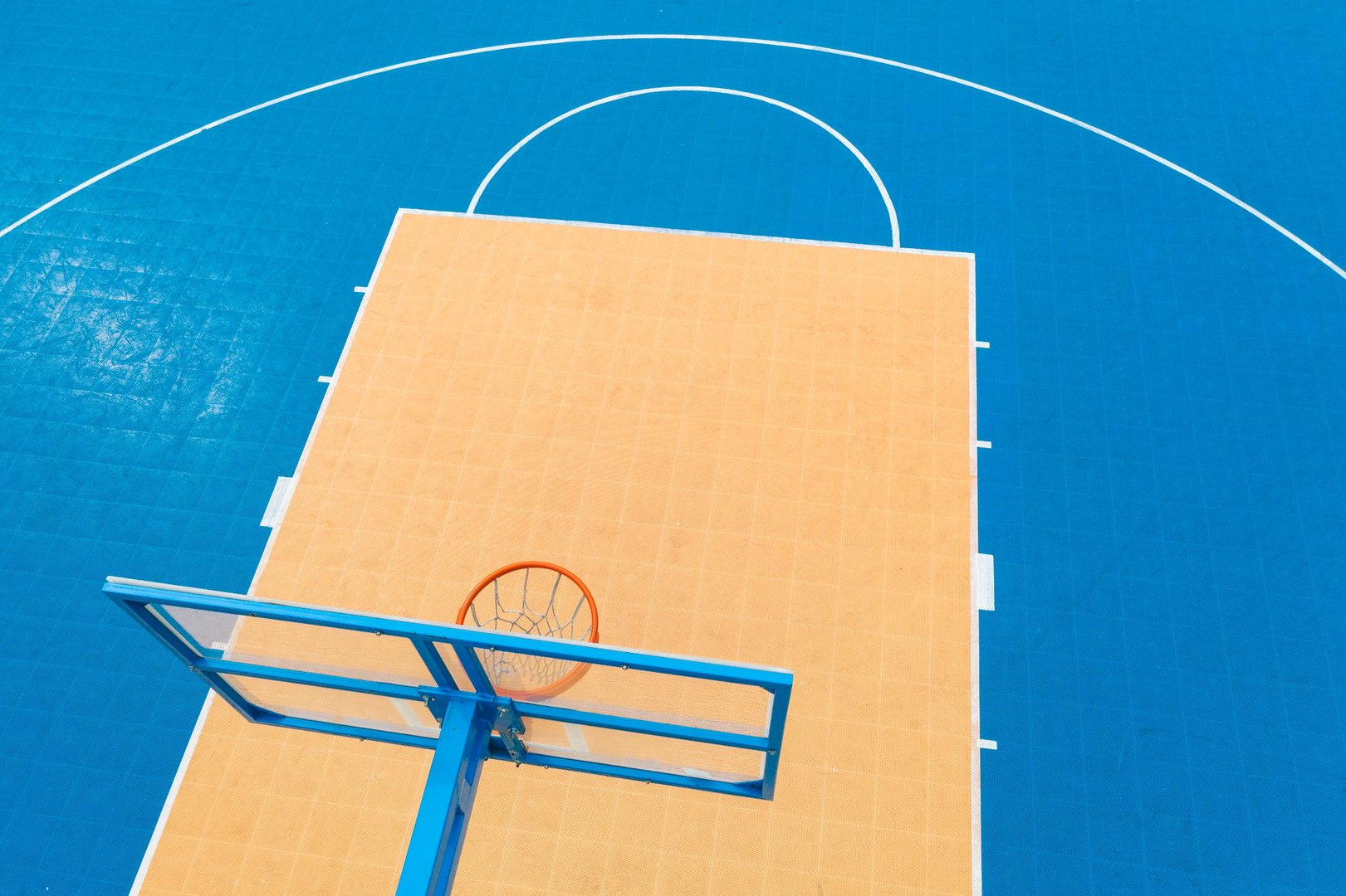 Directly above of the blue and yellow basketball court.