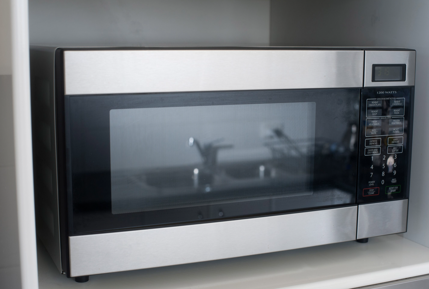 Technician performing microwave radiation leakage test using handheld radiation tester.