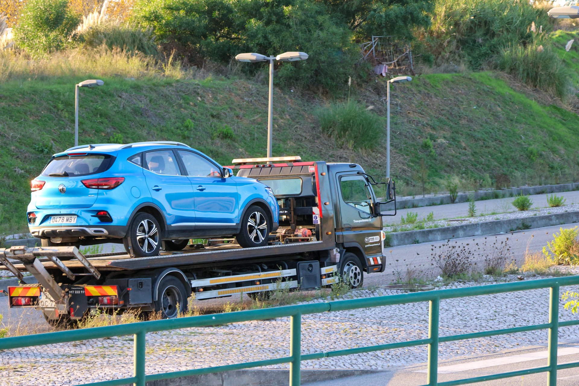 Lisbon, Portugal October 21, 2024, truck is carrying a broken blue suv car on the platform