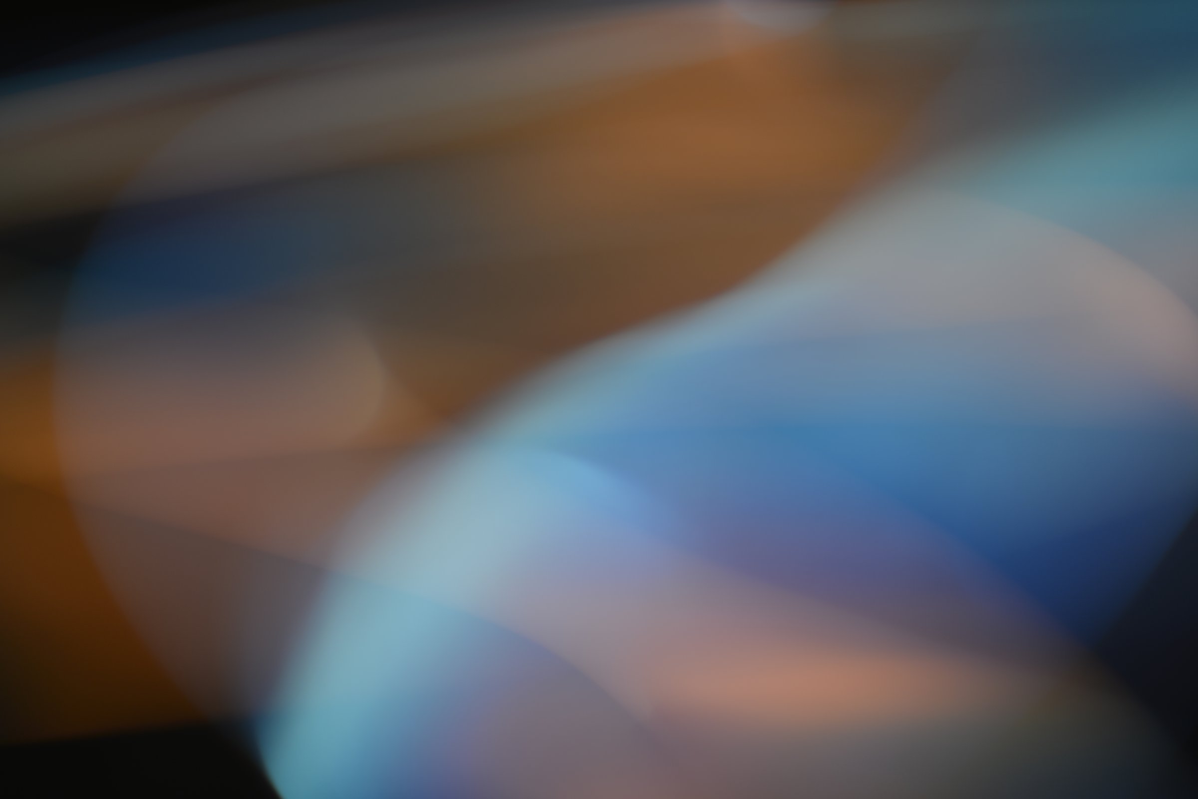 light trails in a long exposure shot. The image features a blend of warm and cool tones, creating a mesmerizing and dynamic visual effect.