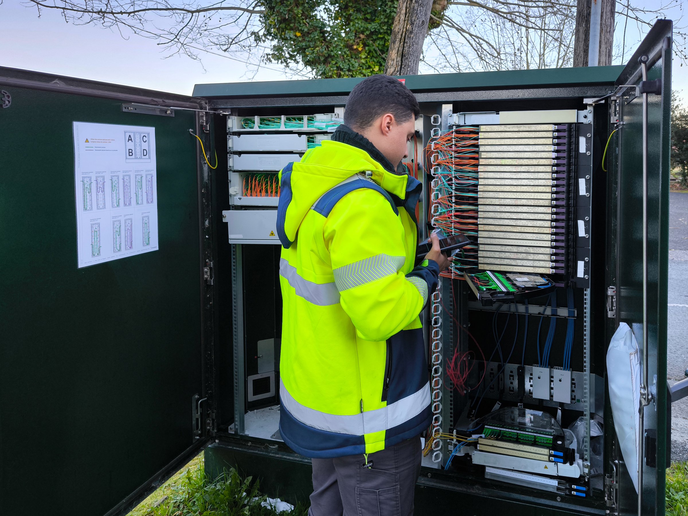 Técnico de telecomunicaciones trabajando en gabinete de fibra óptica