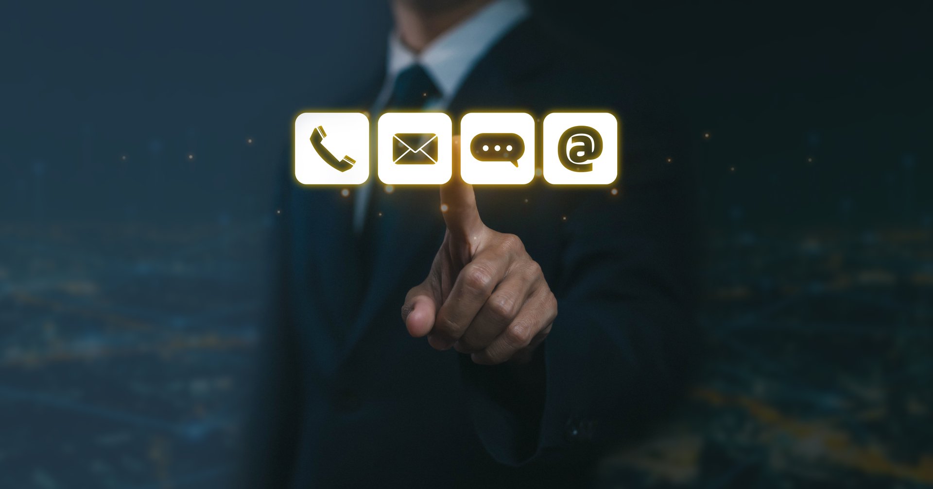 Businessman touching glowing contact icons including phone, email, chat, and internet symbol, representing digital communication, customer support, and modern business connection.